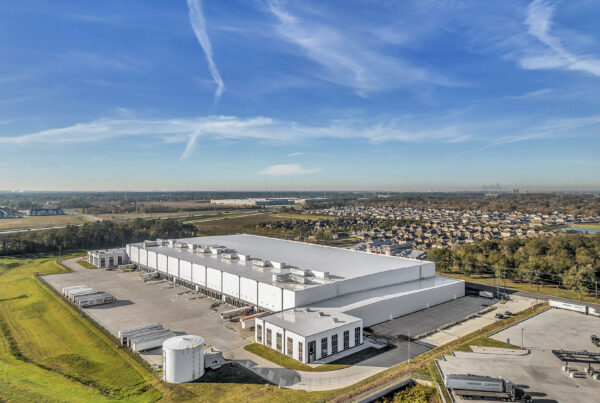 Aerial View of Industrial Warehouse - Aerial shot of an industrial facility with surrounding infrastructure.