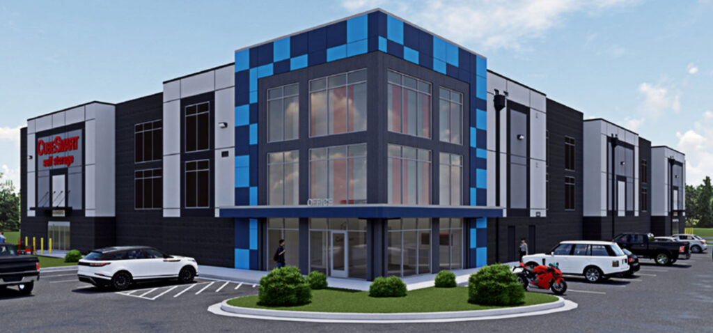 Modern office building with blue accents, large windows, parked cars, and a motorcycle in the foreground.